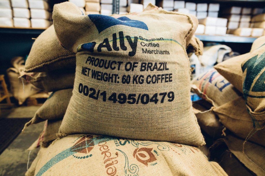 Stack of Brazilian coffee bags in a warehouse, highlighting global trade and commerce.